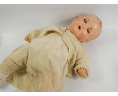 An early 20thC Armand Marseille bisque headed baby doll, with blue sleep eyes, composition body and articulated limbs, the he