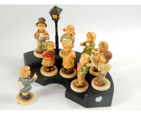 A Hummel Collectors Club set of carol singers, on a wooden stand, (9).