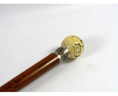 A Japanese malacca walking stick, with an ivory knop, Meiji period, carved with Tengi and a female deity, signed, white metal