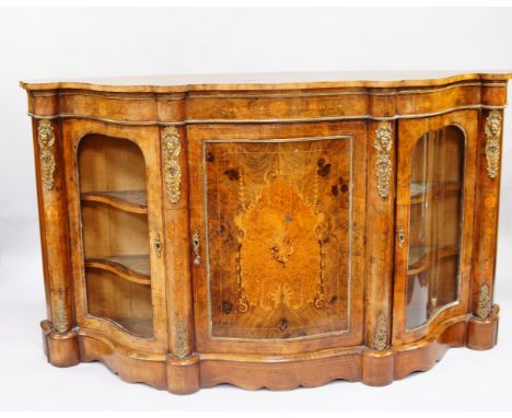 A Victorian walnut and inlaid credenza, of serpentine form, with brass mounts, central door enclosing a single shelf, flanked