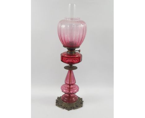 A Hinks & Son cranberry glass and brass oil lamp, late 19thC, with ruby glass reservoir and etched glass shade, 70cm high.