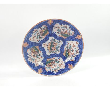 A Dutch delftware charger, polychrome decorated with reserves of baskets of flowers against a blue foliate scroll ground, pai