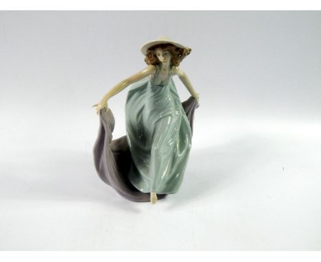 A Lladro porcelain figure of a lady, in a green dress with lilac cape, 22cm high.