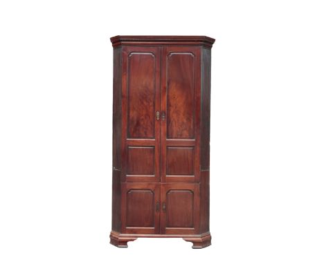 A GEORGE II RED WALNUT CORNER CUPBOARD the dentil moulded cornice over two cupboards, the upper doors opening to a shelved an