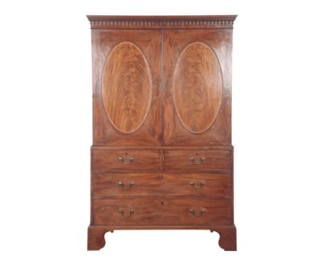 A GEORGE III MAHOGANY LINEN PRESS the upper section with a moulded cornice over oval panelled and crossbanded cupboard doors 