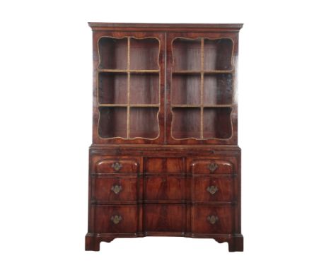 AN ANGLO-AMERICAN WALNUT AND PARCEL-GILT BOOKCASE the upper section with a moulded pediment over glazed cupboard doors with s