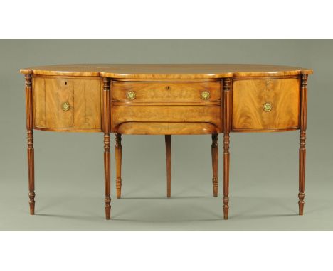 An unusual late Regency mahogany sideboard, having a bowfront back and breakfront, above two central oak lined drawers flanke