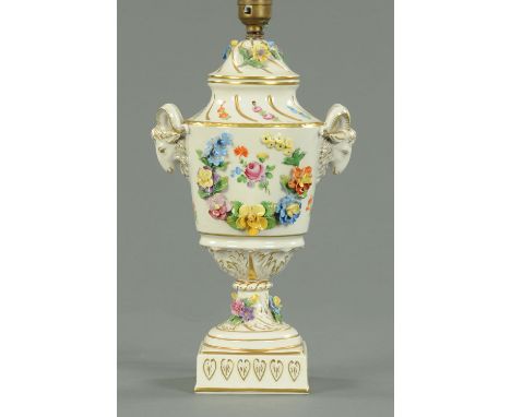 A Dresden porcelain lamp base, with floral encrustations, with ram mask handles heightened with gilding.  Height excluding sh