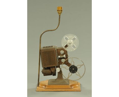 A vintage projector, now converted to a table lamp and raised on a wooden base.  Height to light fitting top 60 cm. 