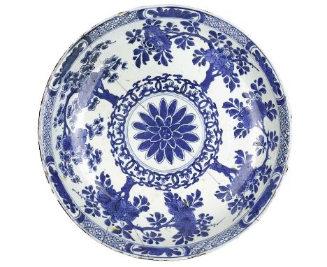 A Chinese blue and white porcelain dish, Qianlong period. The central flowerhead surrounded by trees, leaf mark to base, heig