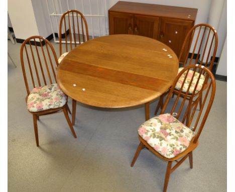 An Ercol style dining room suite, comprising drop leaf dining table, four spindle back chairs and sideboard