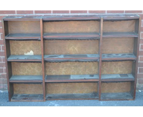 An oak wall shelf with an arrangement of sections