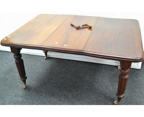 A Victorian mahogany wind out dining table, rounded square top, turned and reeded legs, brass terminals, ceramic casters, cir