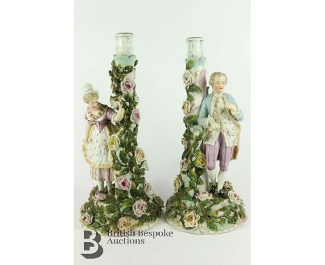 Pair of German figural candlesticks, he approx 38 cms h and she 39 cms, both figures leaning against a tree-trunk profusely d
