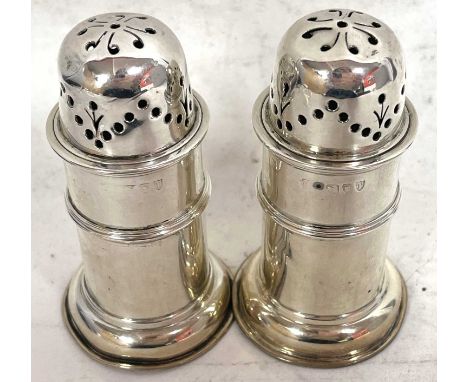 A pair of Victorian silver peppers of lighthouse form with pull off pierced lids and reeded edges on a spreading foot, 8cm ta