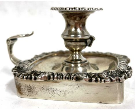 An Edwardian silver chamber stick of square form with a shell and gadrooned border, scroll leaf handle, Sheffield 1904, maker