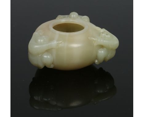 A Chinese Qing dynasty carved celadon jade brush pot modelled with three figures clambering to its side walls, 9.25cm wide.  