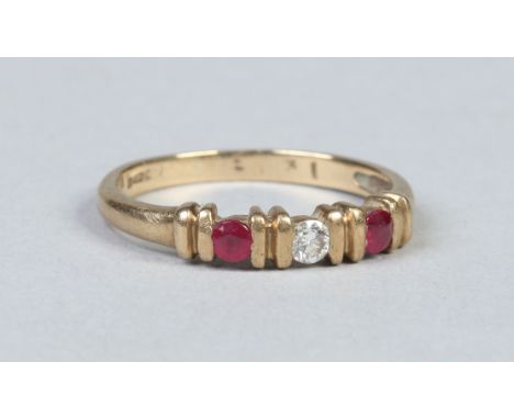 A 9 carat gold ring set with a round cut diamond flanked by a pair of rubies. Size K.   Condition Report. To be used as a gui