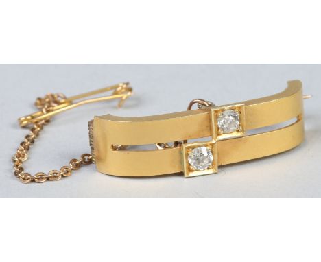 A yellow metal bar brooch set with a pair of round cut diamonds, approximately 0.1ct each, 3cm.   Condition Report. To be use