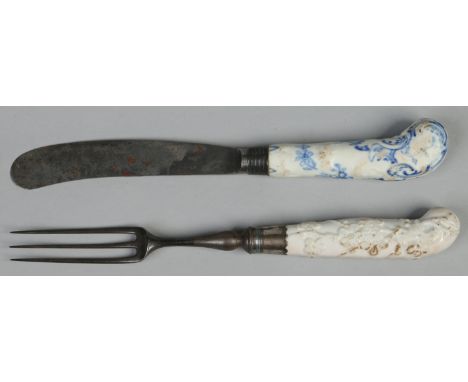 A matched Bow pistol gripped knife and fork. One blanc de chine moulded with prunus blossom and the other painted in undergla