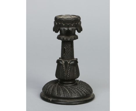 An Irish carved bog oak candlestick. Ornamented with clover leaves to the sconce and formed as a castle turret, 16cm.   Condi
