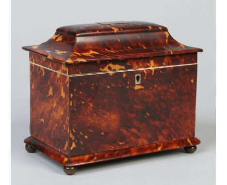 A Regency tortoiseshell tea caddy housing two lidded compartments and raised on four brass ball feet, 19.75cm wide.    Condit