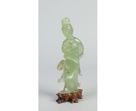 A Chinese carved jade figure on hardwood stand. Formed Guanyin holding a ruyi sceptre and palm leaf, 18.5cm.   Condition Repo