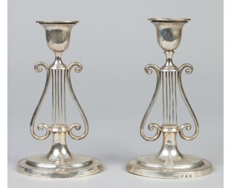 A pair of Victorian silver candlesticks by J. R. Ltd. With detachable oval nozzles, raised on openwork lyre pedestals over ov