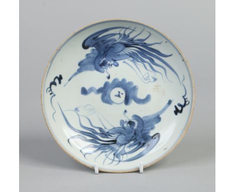 An 18th century Chinese saucer dish. Painted in underglaze blue with broad strokes depicting two phoenix in flight around a c