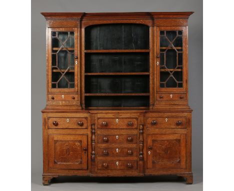 A George III oak and mahogany breakfront kitchen dresser. The top with astrigal glazed cupboard flanking a central open delft