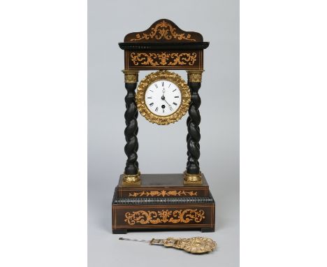 A 19th century French portico mantel clock with marquetry inlay. Supported on ebonized Solomonic columns with gilt metal capi