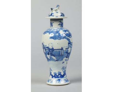 A 19th century Chinese baluster vase and cover with dog of fo finial. Painted in underglaze blue with a garden landscape with