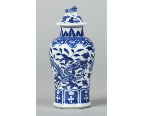 A 19th century Chinese small baluster vase and cover. With moulded dog of fo finial and painted in underglaze blue with a ruy