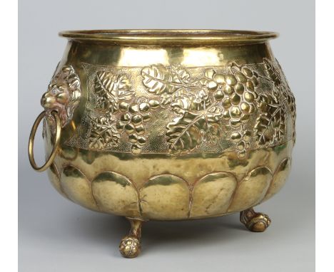 An early 20th century embossed brass planter. With twin lion mask handles and raised on paw feet, 40cm wide.   Condition Repo