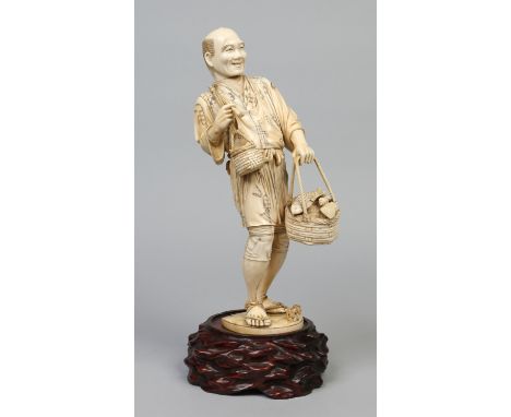 A Japanese Meiji period large ivory sectional okimono on hardwood plinth. Modelled in the form of a fisherman returning home 