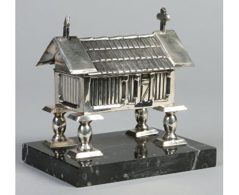 A white metal jewellery casket modelled in the form of a chapel and raised on a rectangular marble plinth. Punch marks to the