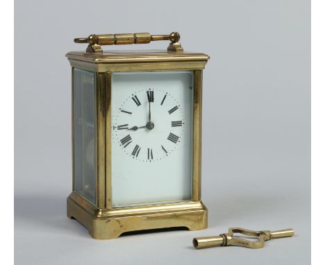 A French brass cased carriage clock with enamel dial having Roman numeral markers and striking hourly on a gong, 15cm.   Cond