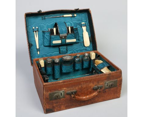 A Victorian fitted leather travelling vanity case with watered silk interior. With ivory, glass and silver accoutrements. Ass