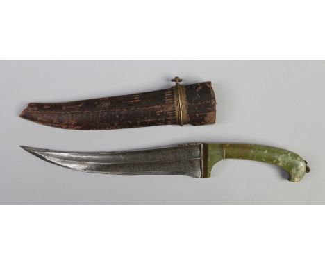 A 19th century Persian dagger in leather mounted sheath. With jade scales and having curved steel blade ornamented with file 