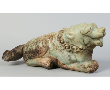 A large Chinese pale green and dark brown opaque jade carving of a recumbent temple lion, 64cm.   Condition Report. To be use