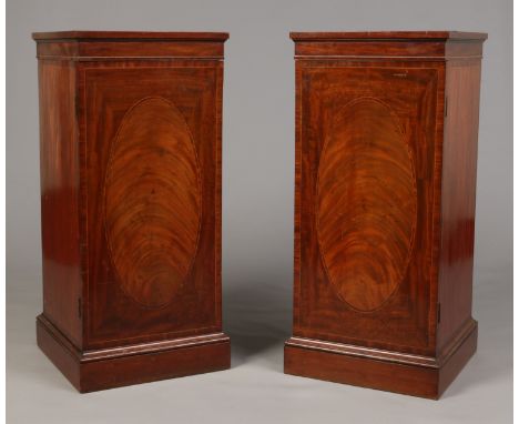 A pair of early Victorian mahogany dining room pedestals. Crossbanded in satinwood and with strung inlay. Each with brass dom
