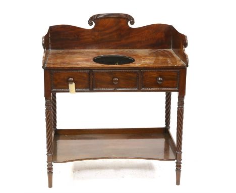 19th century mahogany wash stand with three dummy drawers to frieze on fluted legs with foliate tops with lower shelf  (basin