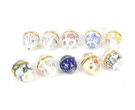 Collection of Halcyon Days and Crummles enamelled eggs of various sizes decorated with flowers, birds, insects etc.,