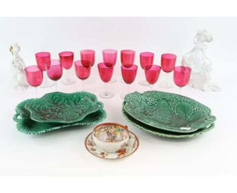 Fourteen cranberry drinking glasses, two Rosenthal figures, four green leaf moulded plates and a Japanese cup and saucer,