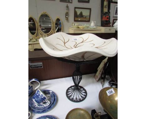 A ceramic bowl on metal stand.