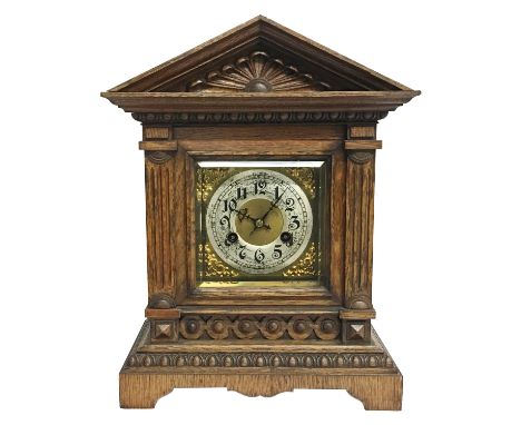 An oak cased mantel clock with brass face, mechanism marked 'Unghans J'.