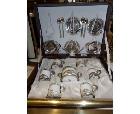A cased 6 place setting Weidman porcelain coffee set encased in 800 silver holders and with 800 silver saucers.