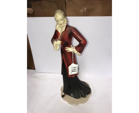 An art deco figure of a lady in red coat with fur trim,.