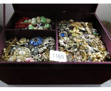 A large red velvet jewellery box containing a large quantity of costume jewellery.