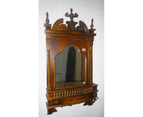 A wood framed mirror with shelf.